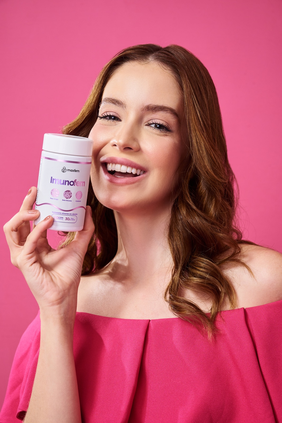 Mujer sonriendo con el frasco de Imunofem en las manos